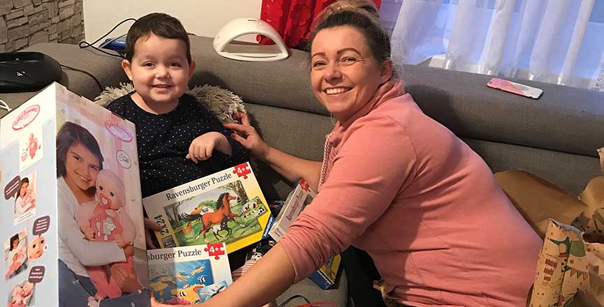 src=https://www.hoerer-helfen-kindern.de/wp-content/uploads/2020/12/Bild-Amelia-bekommt-Geschenke-von-Hoerer-helfen-Kindern.jpg