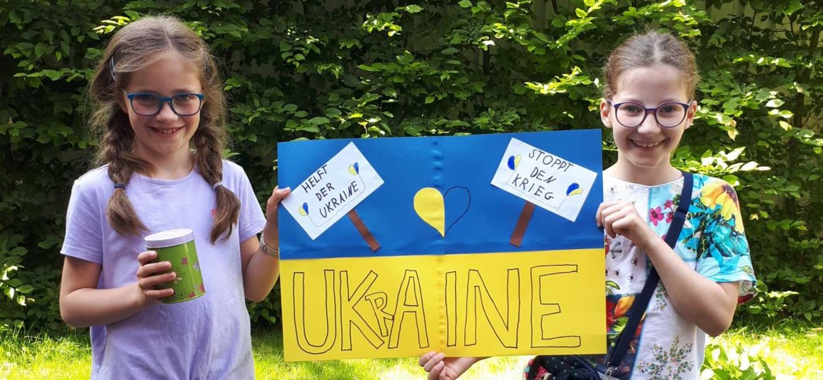Introbild Pia und Rosalina spenden für Hörer helfen Kindern mit Spendenplakat