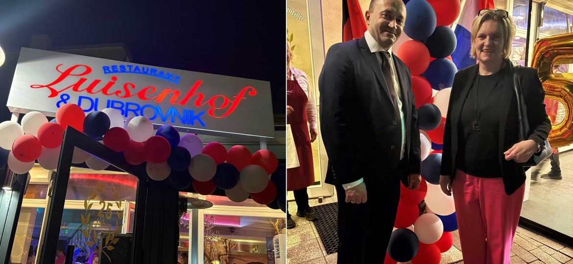 Restaurant storefront decorated with red, white, and blue balloons and a sign in cursive text above the entrance (nighttime storefront shot).