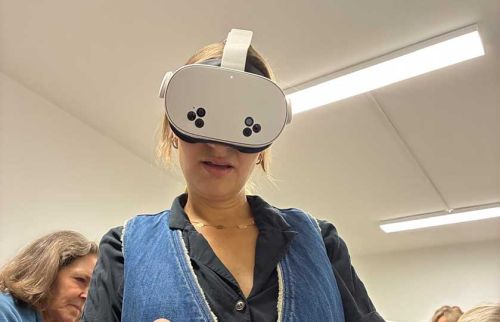 Person wearing a white VR headset in a bright indoor room.