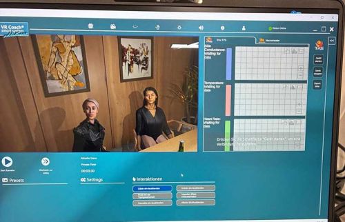 Screenshot of VR Coach interface showing two women seated in a wood-paneled room on the left and a data grid panel on the right.